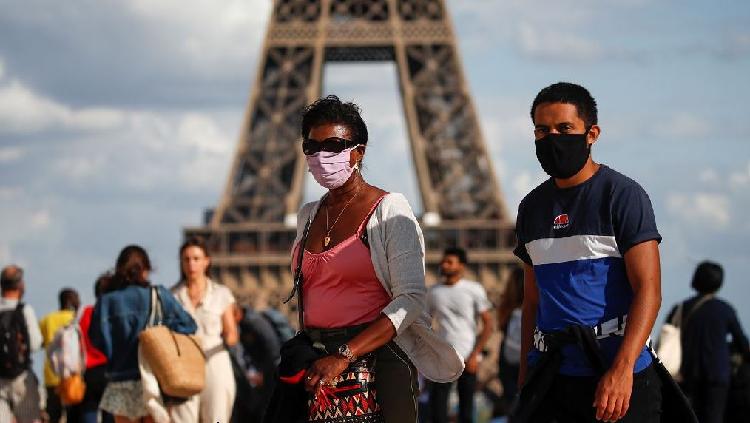 Customers wearing protective face masks strolling close from Chanel store  on the Champs Elysee avenue on May 11, 2020 in Paris, France. France began  a gradual easing of its lockdown measures and