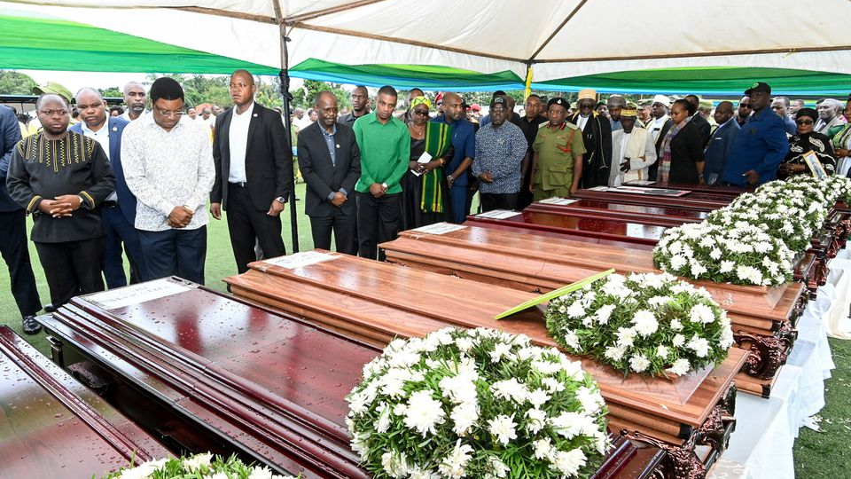 Tanzanian Prime Minister Kassim Majaliwa stands in front of the coffins as he pays homage to the victims following the crash of the Precision Air ATR 42-500 passenger plane that crash landed into Lake Victoria. /Reuters