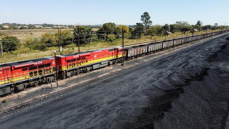 A Transnet Freight Rail train is seen next to tons of coal mined from the nearby Khanye Colliery mine, at the Bronkhorstspruit station, in Bronkhorstspruit, around 90 kilometres north-east of Johannesburg, South Africa, April 26, 2022. /REUTERS