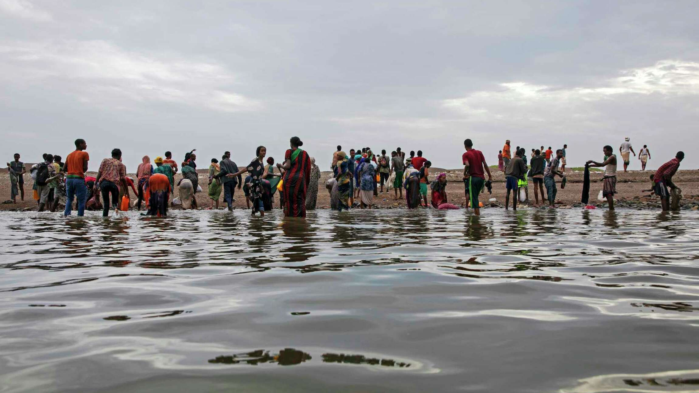 Ethiopian migrants walk on the shores of Ras al-Ara, Lahj, Yemen, after disembarking from a boat, July 26, 2019. /AP)
