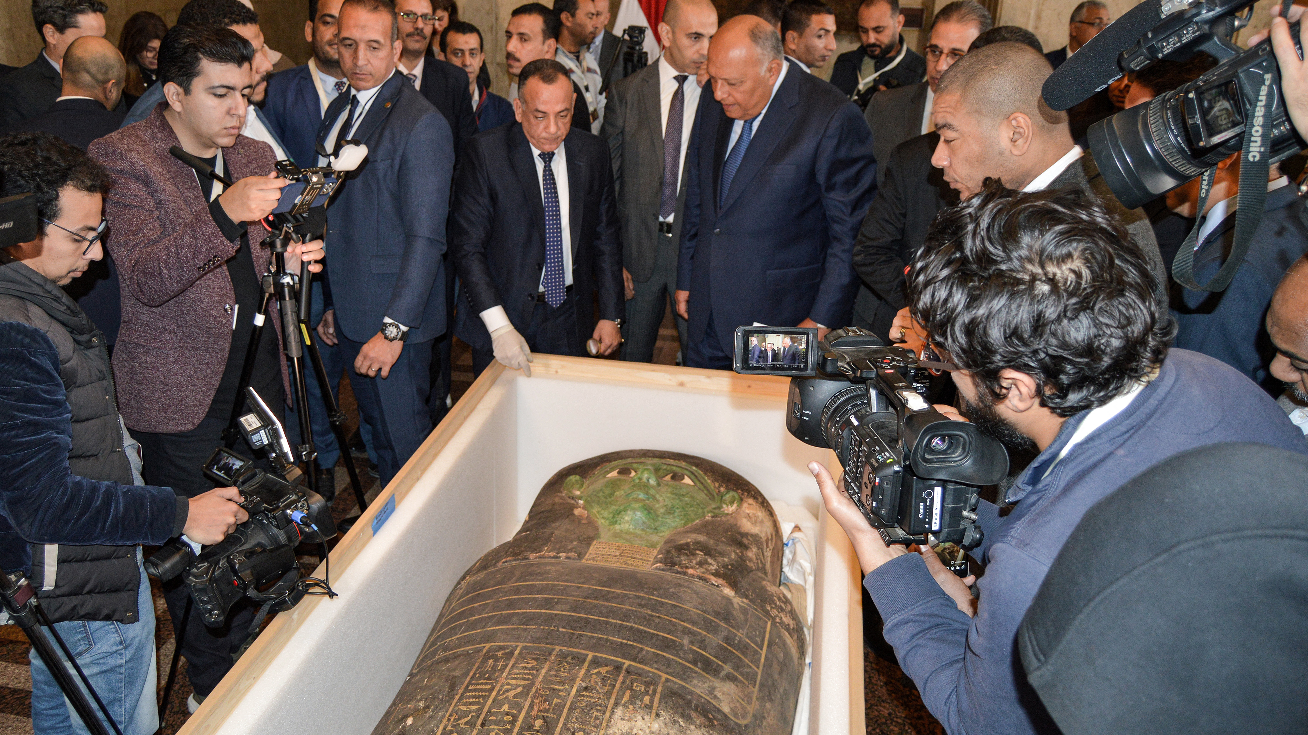 Egypt's Foreign Minister Sameh Shoukry and the head of the Supreme Council of Antiquities Mostafa Waziri inspect an ancient Egyptian wooden sarcophagus at the foreign ministry headquarters in the capital Cairo. /AFP