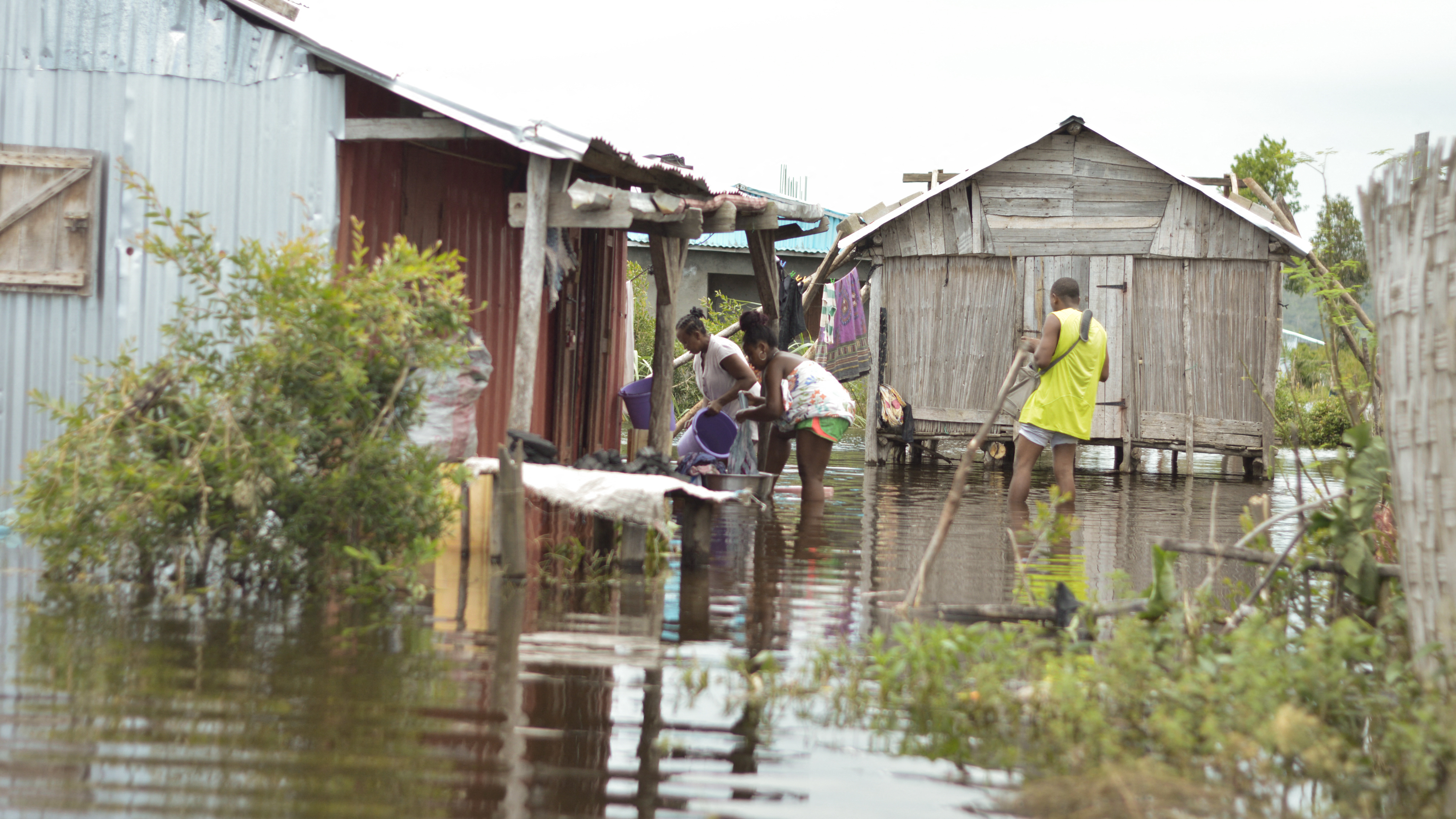 Residents of the Belle Souvenir neighborhood try to resume their daily life in their house submerged by water in Sambava on January 21, 2023, following the passage of cyclone Cheneso on January 19, 2023. / AFP