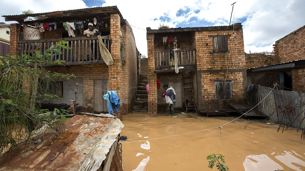 Residents stood on balconies overlooking residential streets flooded by rain in Antananarivo, Madagascar. /CFP