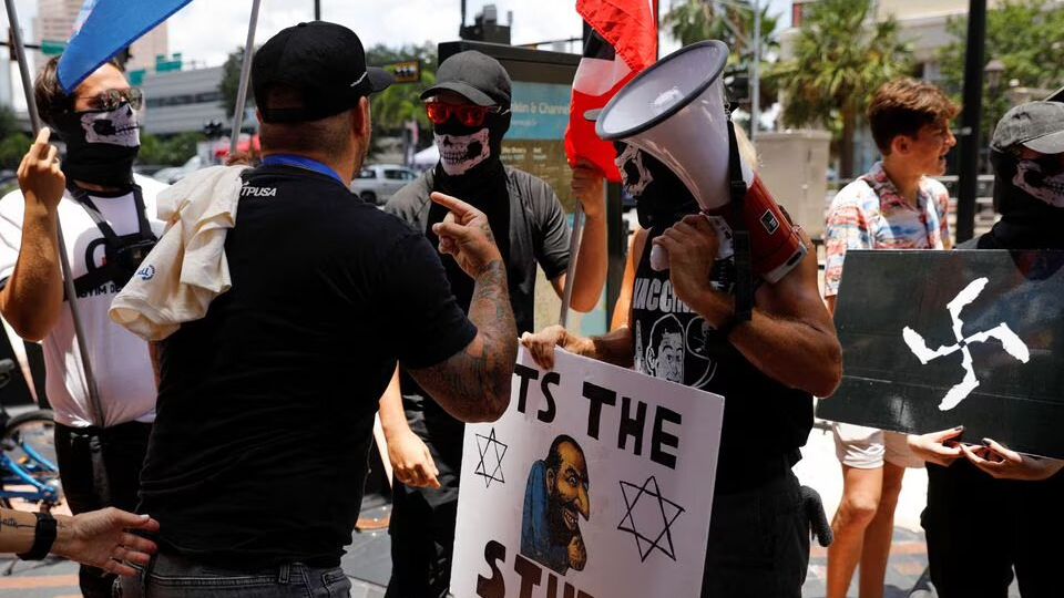 People wearing antisemitism and nazi symbols argue with conservatives during a protest outside the Tampa Convention Center where the Turning Point USA's (TPUSA) Student Action Summit (SAS) is held, in Tampa, Florida, U.S. July 23, 2022. /REUTERS