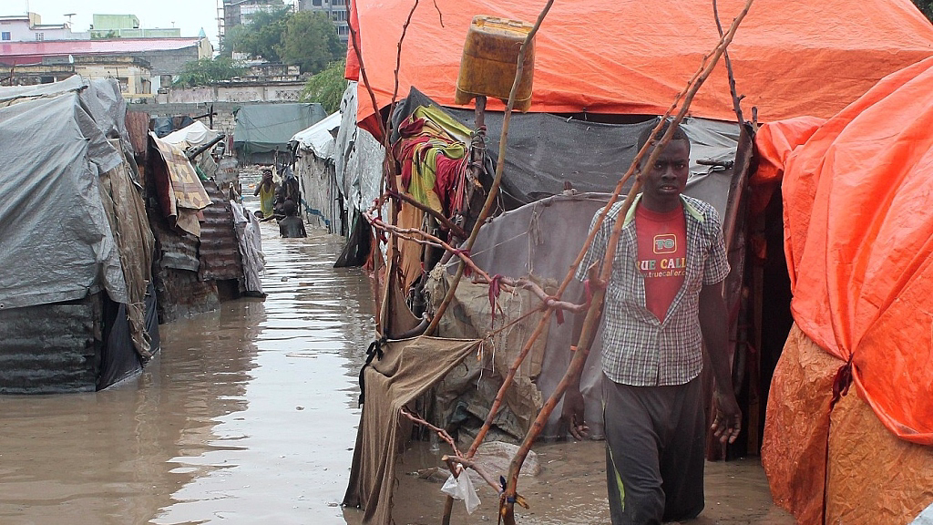 FILE PHOTO: People walk through flood waters after heavy rains in Somalia. /CFP