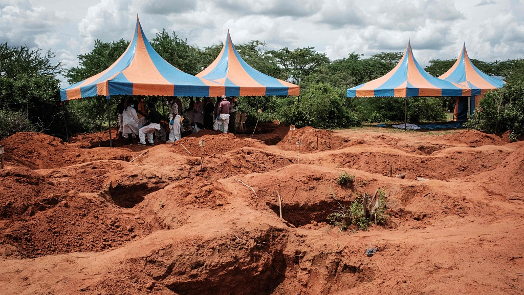 FILE PHOTO: Workers take shelter while digging the ground to exhume bodies from the mass-grave site in Kenya. /CFP