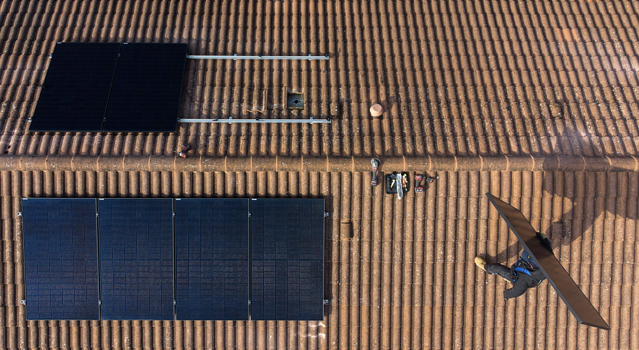 An engineer carries a DualSun SAS hybrid solar panel (PVT) onto the roof of a home during a residential installation in Saint Denis en Bugey, France, on March 3, 2023. /CFP