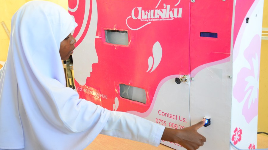 A schoolgirl of Salma Kikwete Secondary School in Tanzania's commercial capital Dar es Salaam collects free sanitary pads from a vending machine installed by non-profit organization Chausiku Foundation on Aug. 7, 2020. /Xinhua