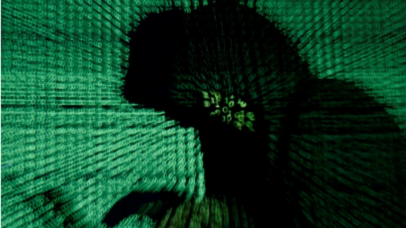 A man holds a laptop computer as cyber code is projected on him in this illustration picture taken on May 13, 2017. /Reuters