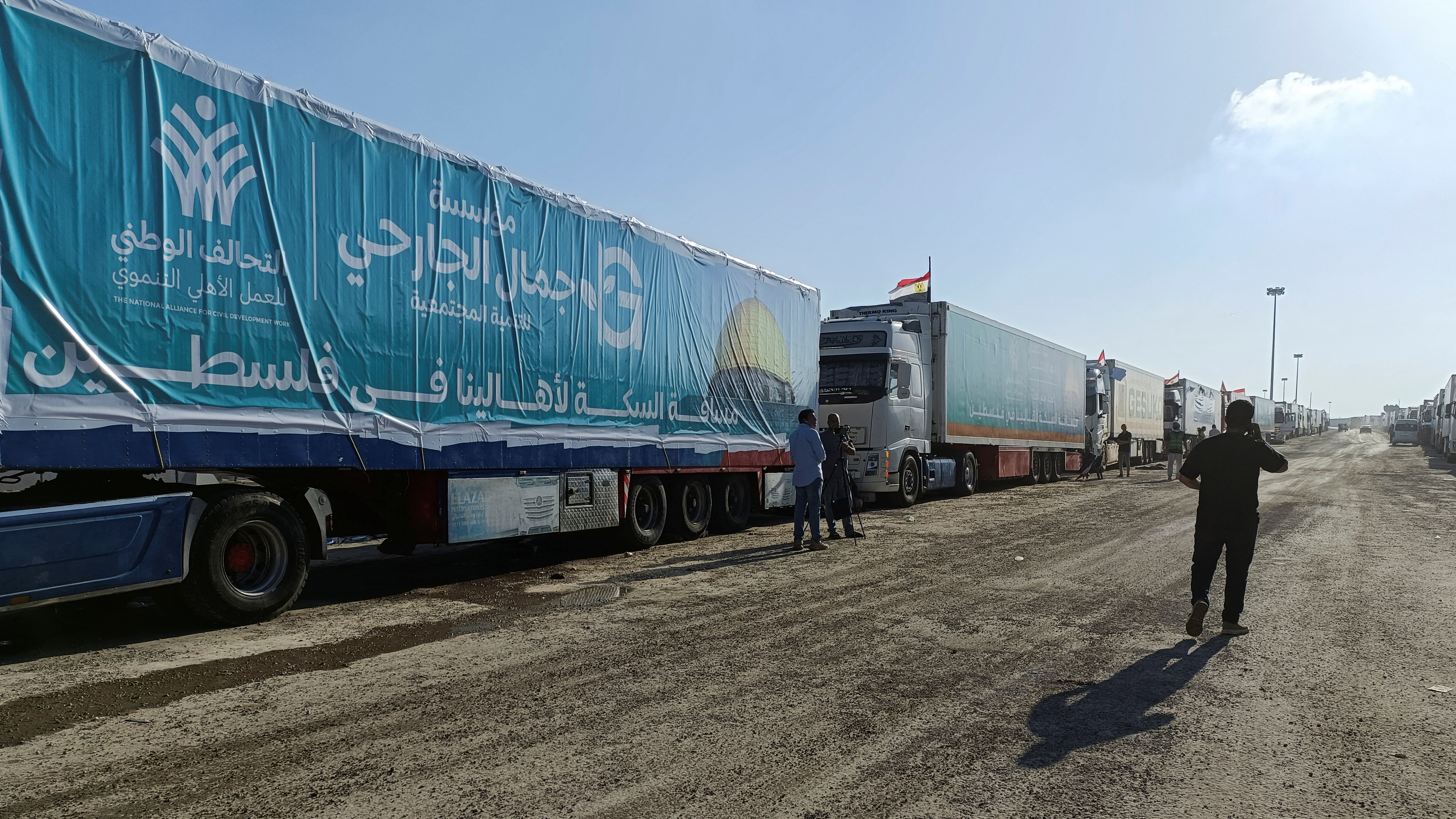 An Egyptian volunteer walks next to trucks carrying humanitarian aid from Egyptian NGOs. /REUTERS