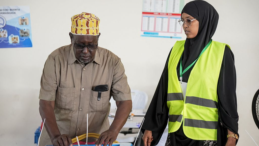 A voter casts his ballot paper at a polling station during local council elections in Mogadishu on December 25, 2025. /CFP