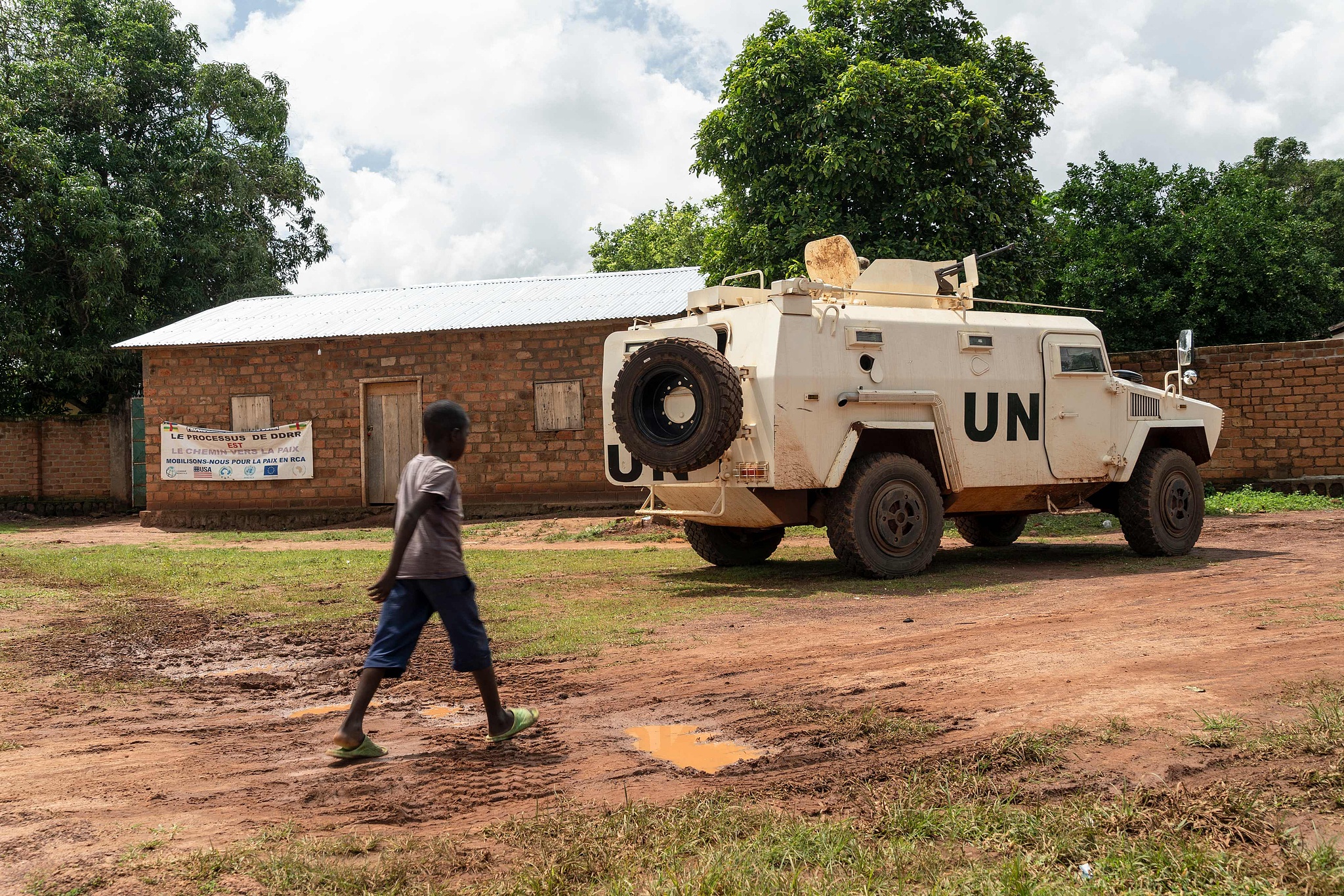 FILE: A child walks past a MINUSCA (United Nations Multidimensional Integrated Stabilization Mission in the Central African Republic) armoured vehicle parked at the DDR (Disarmament, Demobilization, and Reintegration) site in Maloum on July 24, 2025. /CFP