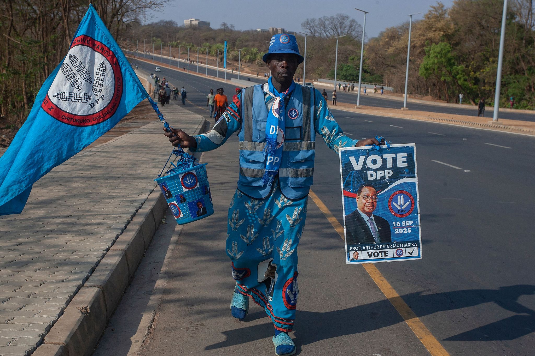 File Phot: A Democratic Progressive Party (DPP) supporter in party regalia carries a poster of Peter Mutharika in Lilongwe, Malawi, September 24, 2025. /CFP