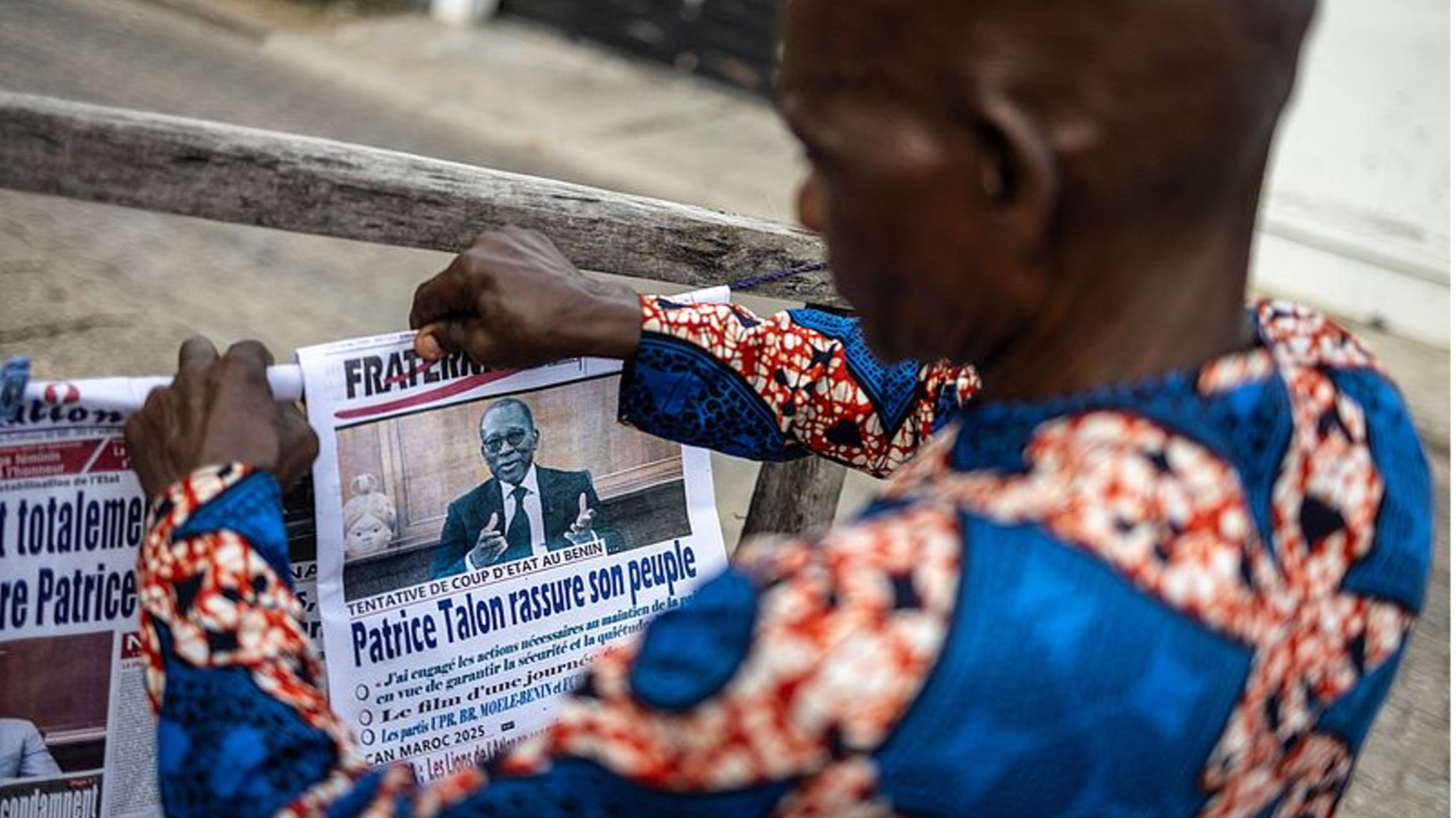 A vendor arranges newspapers on a stall in Cotonou, on December 8, 2025 as Benin's president said the 