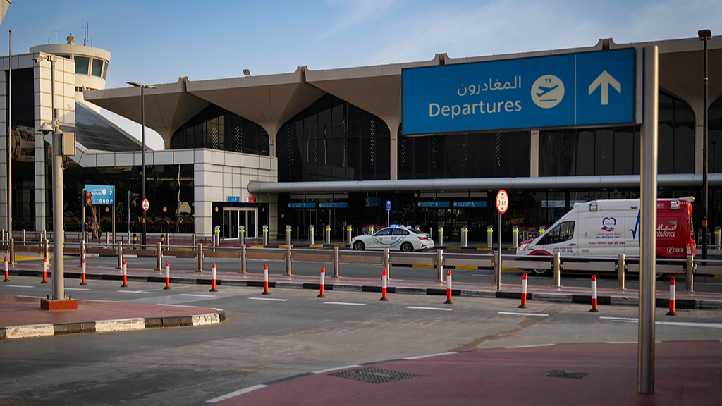 A police vehicle and an ambulance are parked on the departure road of Dubai International Airport, which lies deserted following its closure. Dubai, United Arab Emirates, March 1, 2026. /CFP