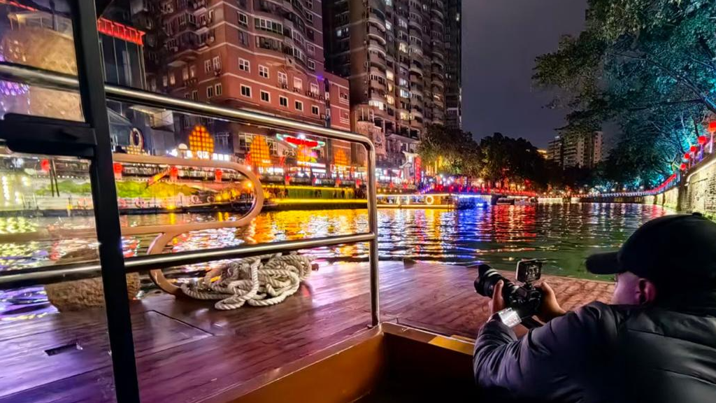 CGTN Africa's Eric Mukanga takes a photograph while on a river cruise on the Jinjiang River, Chengdu, China, February 25, 2026. /Peninah Karibe, CGTN