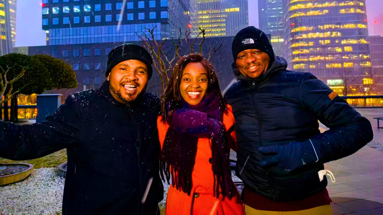 Enock Sikolia (L), Peninah Karibe (C), and Eric Mukenga (R) pose for a picture as snow falls in Beijing, China, in February 2026. /CGTN