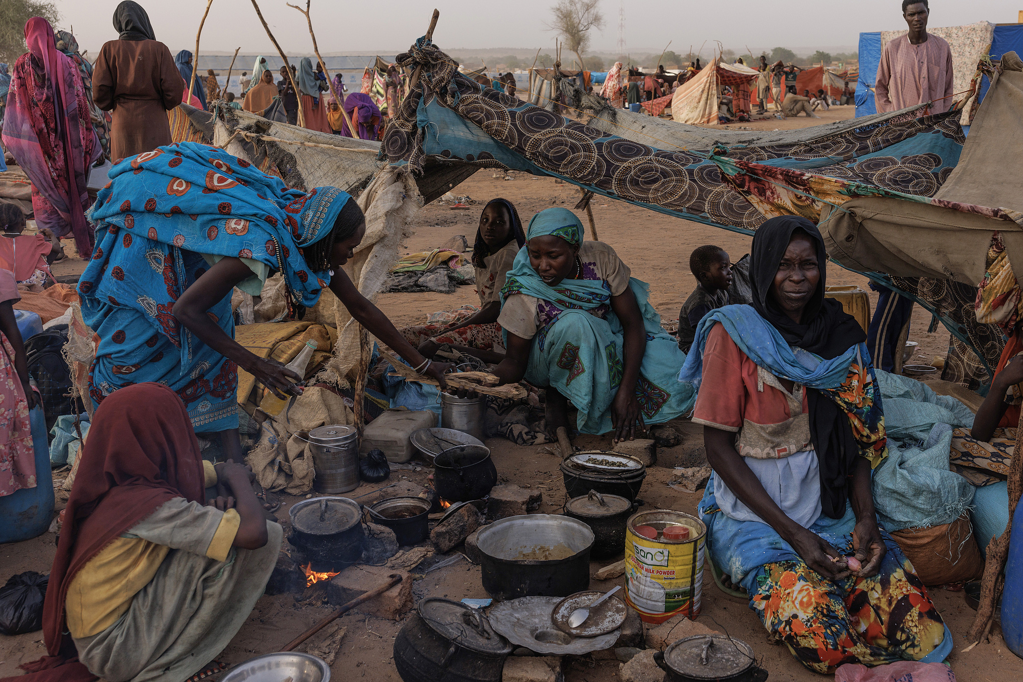 Newly arrived Sudanese refugees cook over a fire outside their temporary shelter at a resettlement camp in Adre, Chad, on April 24, 2024. /CFP