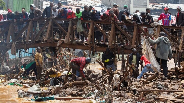 People watch as others comb through washed-up waste along the Nairobi River after floods from heavy rainfall in Nairobi, Kenya, on March 7, 2026. /Reuters
