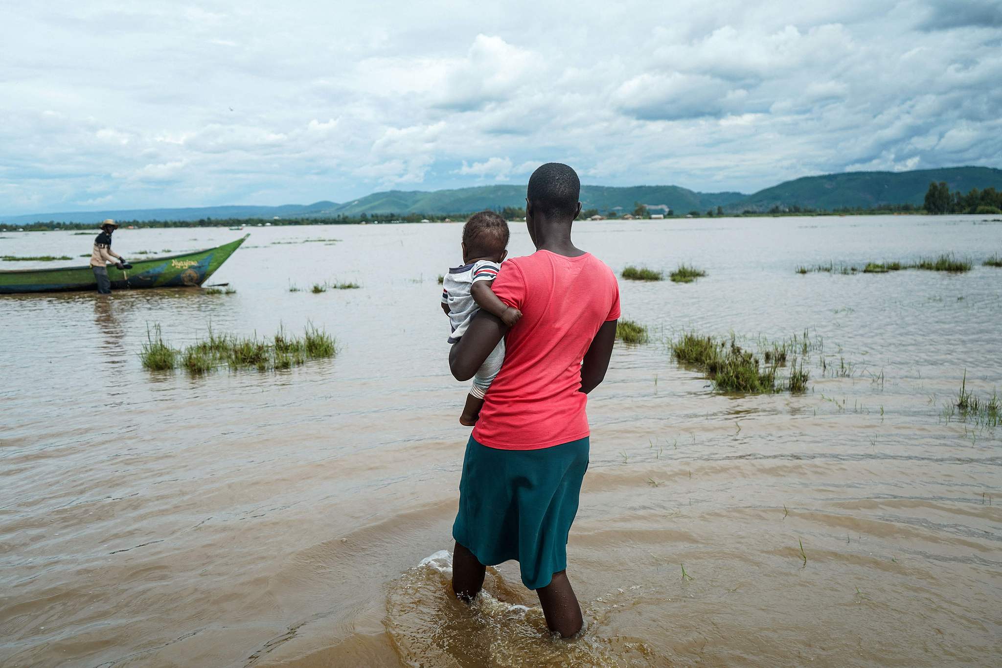 A resident walks with her child through a flooded area in West Nyakach, Kisumu County, Kenya, March 22, 2026. /CFP
