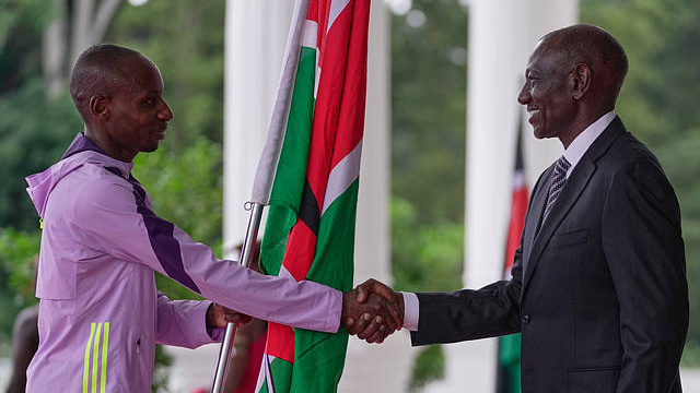 Kenyan marathon record-breaker Sabastian Sawe, left, returns the Kenyan flag to President William Ruto at State House in Nairobi, Kenya, Wednesday, April 30, 2026. /CFP