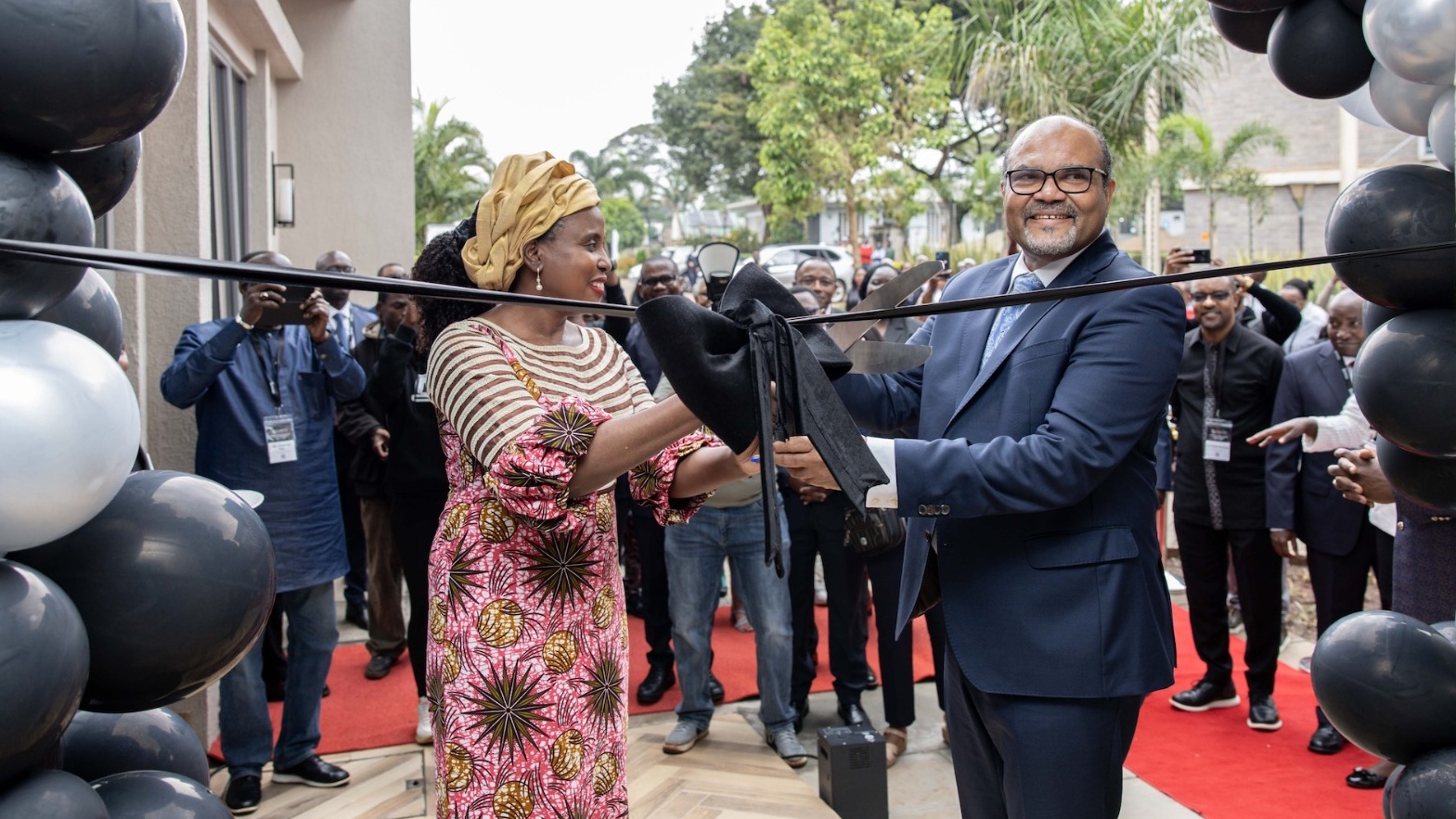 APHRC Executive Director Catherine Kyobutungi (left), and Kenyan Principal Secretary for Science, Research and Innovation, Ministry of Education Shaukat Abdulrazak cutting the ribbon for the Ulwazi II building,  during the APHRC 25th anniversary and Ulwazi II launch in Nairobi, Kenya, May 13, 2026. /APHRC