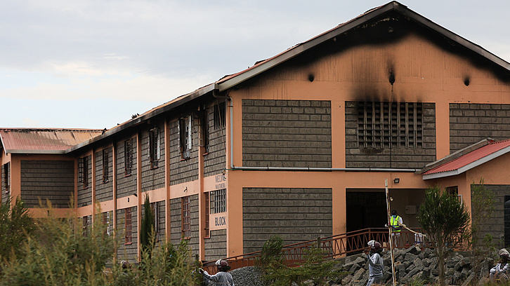 People stand near a dormitory building at Utumishi Girls Academy after part of it caught fire overnight in Nakuru, 120 kilometres northwest of Nairobi, Kenya, 28 May 2026. /CFP