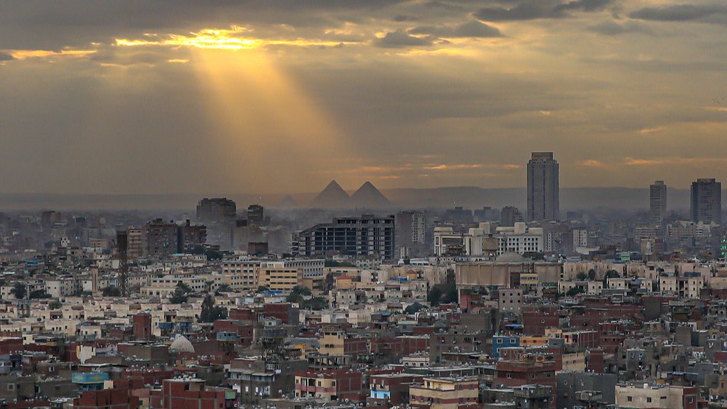 File: Residential and commercial buildings on the city skyline, against the backdrop of the Giza pyramid complex, are viewed from the Citadel of Saladin in Cairo, Egypt, January 7, 2023. /CFP