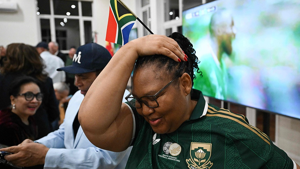A South African fan reacts after Mexico scores its first goal while watching a live broadcast of the FIFA World Cup Group A match between Mexico and South Africa at the Mexican embassy in Beijing on June 12, 2026. /CFP