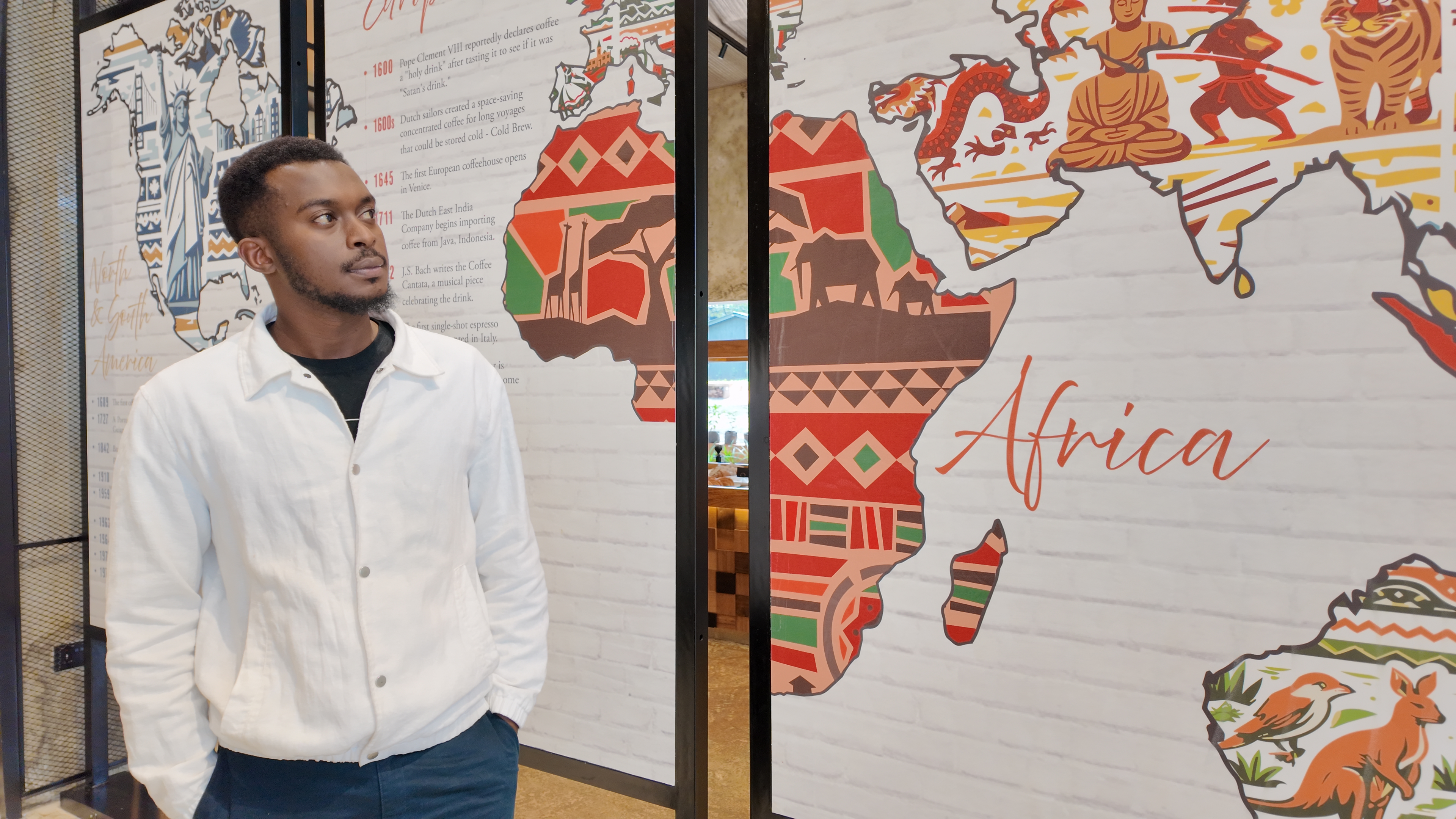Artist Cyprian Kiswili with his artwork at a Nairobi coffee shop in Nairobi, Kenya, June 15, 2026. /CGTN Africa