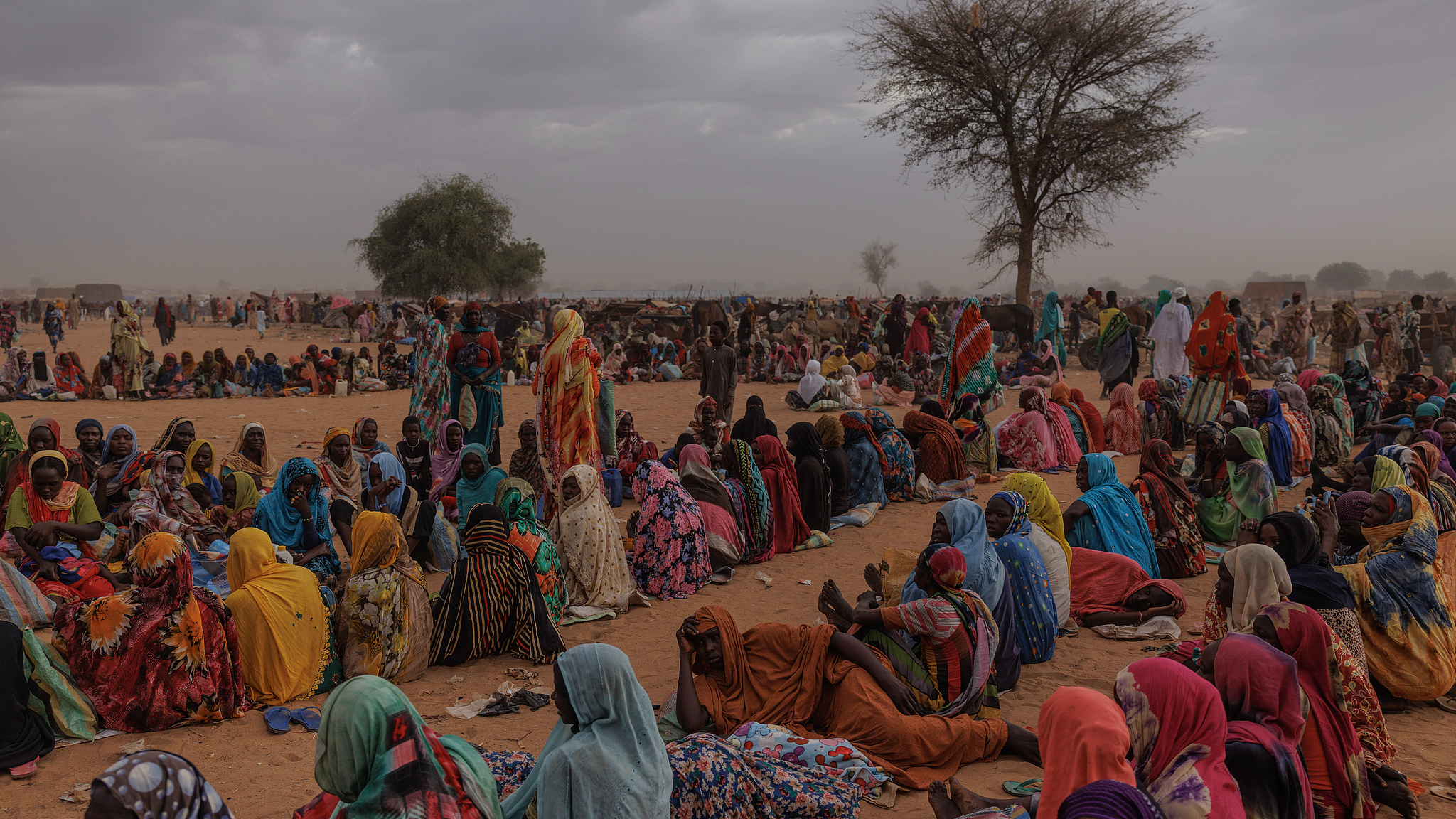 Refugees, mainly women and children, wait for a World Food Programme food distribution point to open in a temporary refugee camp, in Adre, Chad, April 22, 2024. /CFP