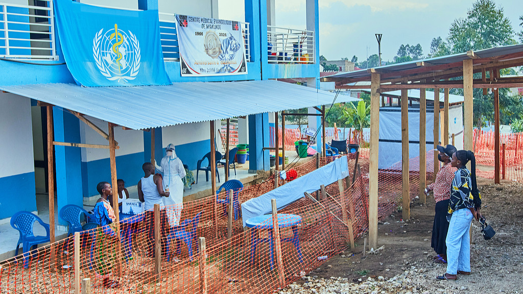 A health worker speaks to people at the evangelical Medical Center, in Bunia, eastern Congo, Friday, July 3, 2026, where Ebola clinical trials are scheduled to take place. /CFP