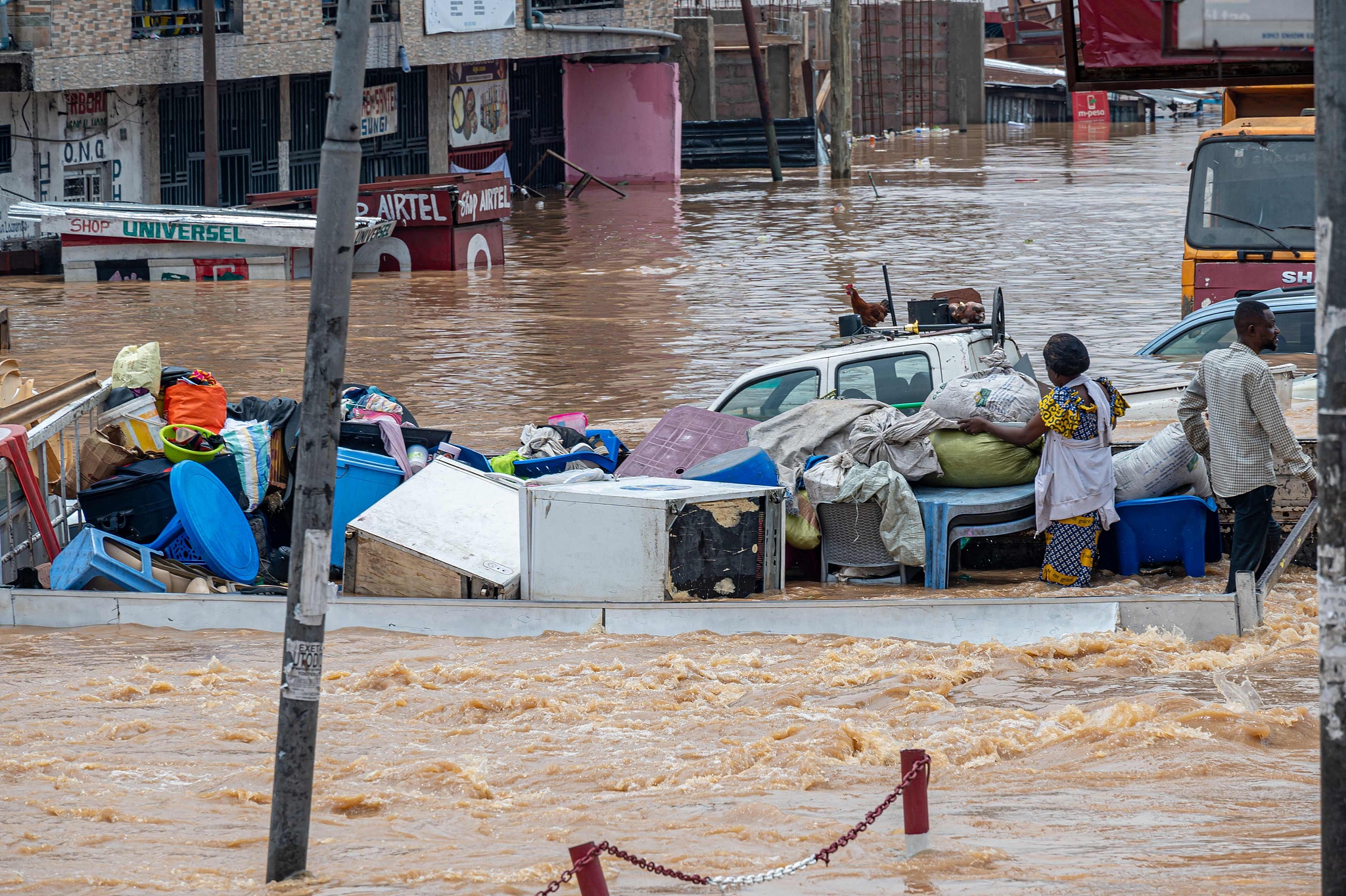 FILE: Residents move their belongings to safety as floodwaters cover a road following heavy rains in the Ndjili district of Kinshasa, DR Congo, April 6, 2025./CFP
