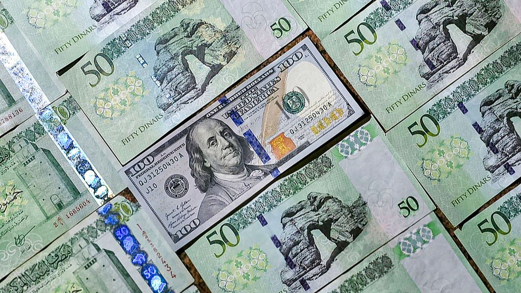Banknotes of the 50 Libyan dinar denomination are pictured around a $100 banknote, in Tripoli, capital of Libya, April 17, 2025. /CFP