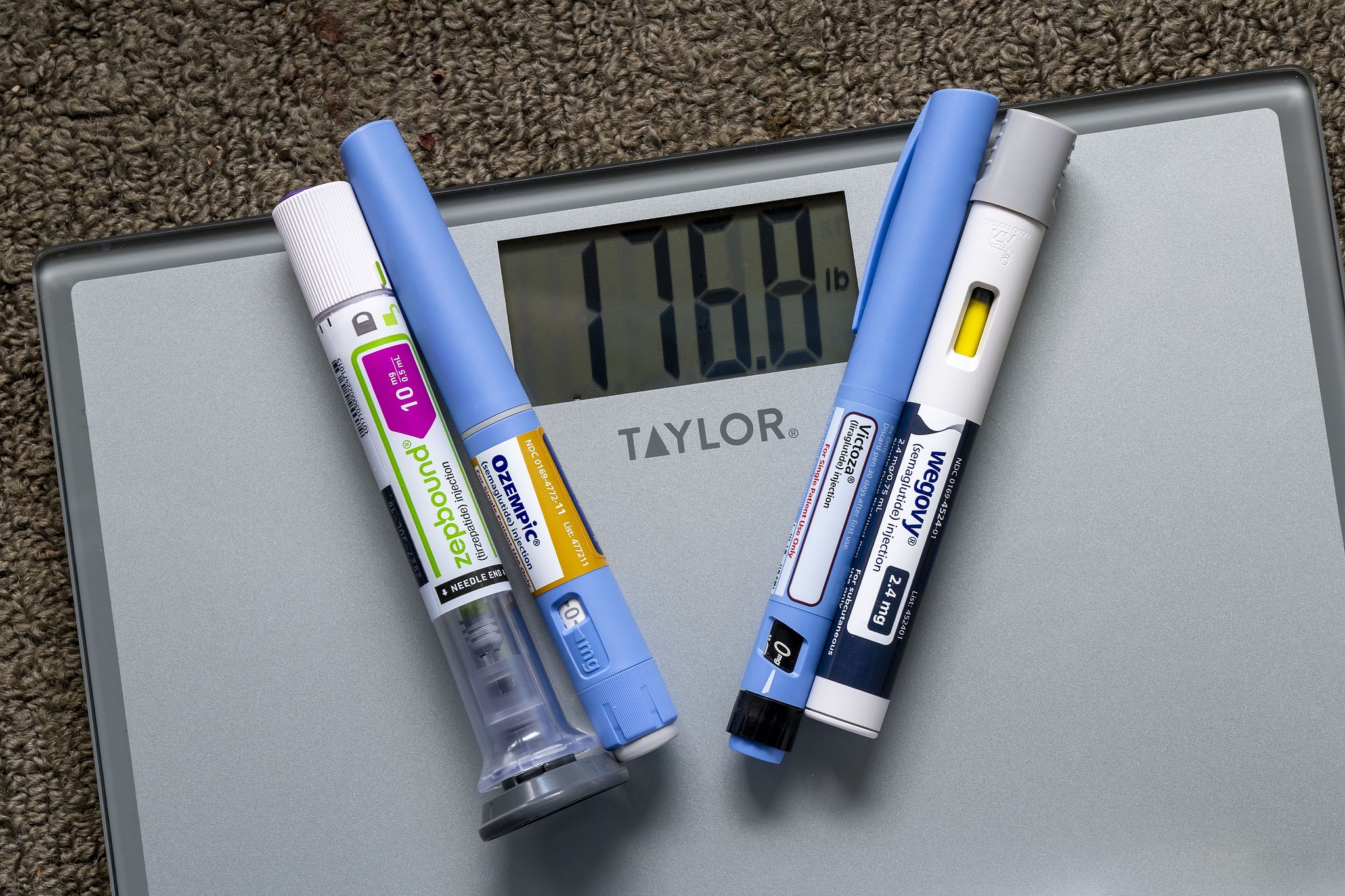 Photo illustration of weight loss injection pens on a weight scale showing 176 pounds. /CFP