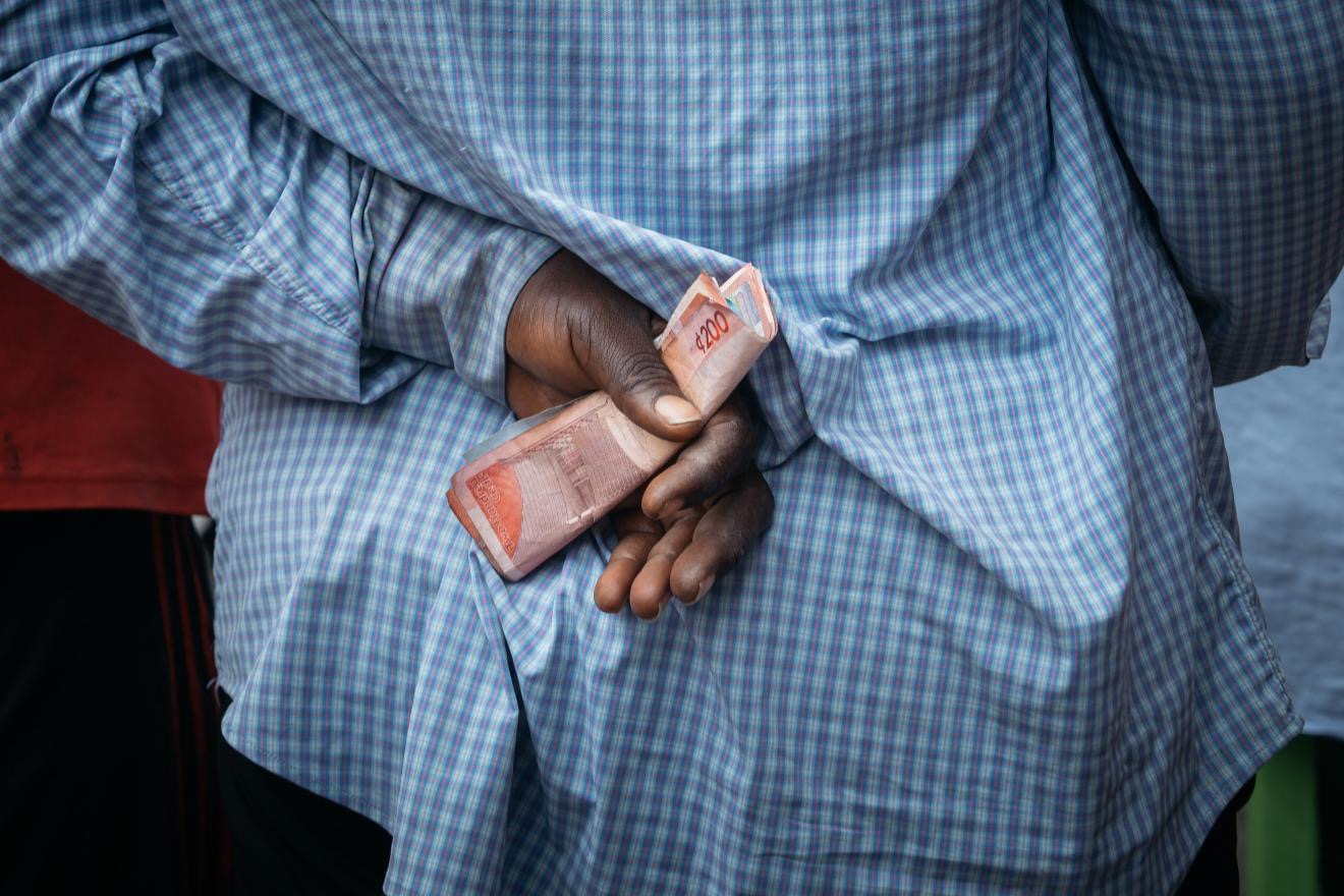 A street vendor holds Ghanaian cedi currency banknotes in a market in Accra, Ghana, on Thursday, July 24, 2025. /CFP