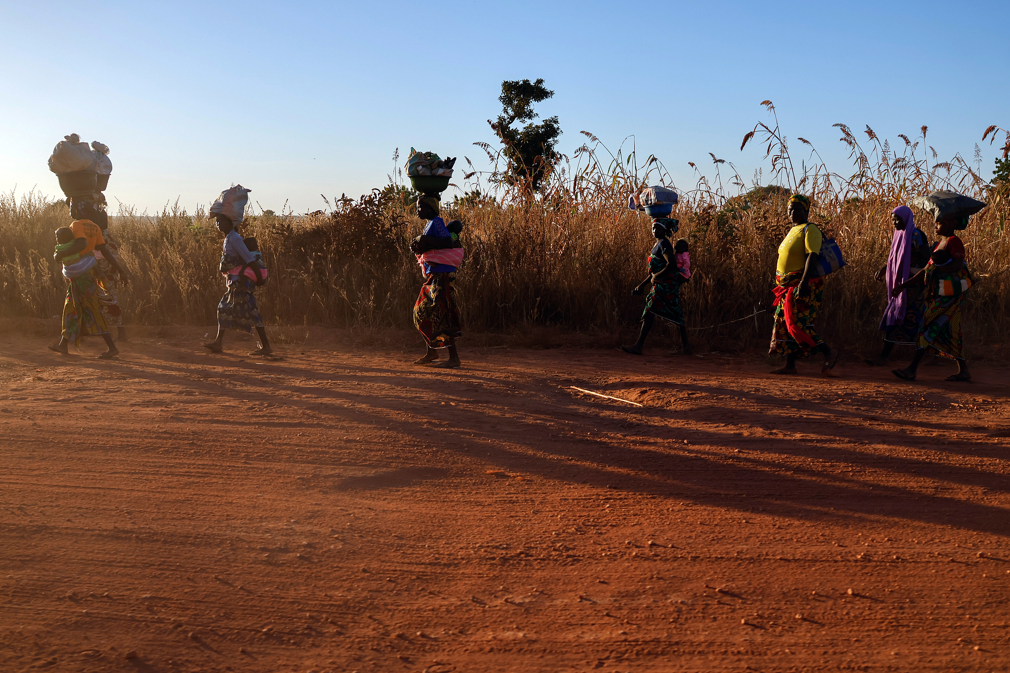Women with children walked along the Kanji-Agwara Highway in Papeiri, Niger State, Nigeria. The remote highway was the site of the mass abduction of 303 students and 12 teachers on November 24, 2025. /CFP