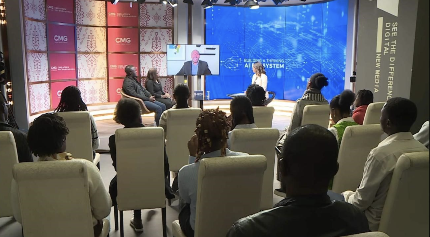 Olubayo Adekanmbi speaks via video link during the town hall discussion, joined by panelists Jasin Owili (L), Consolata Maitha (2nd L), and Peninah Karibe (R), alongside an audience of students from the University of Nairobi and Daystar University. /CGTN