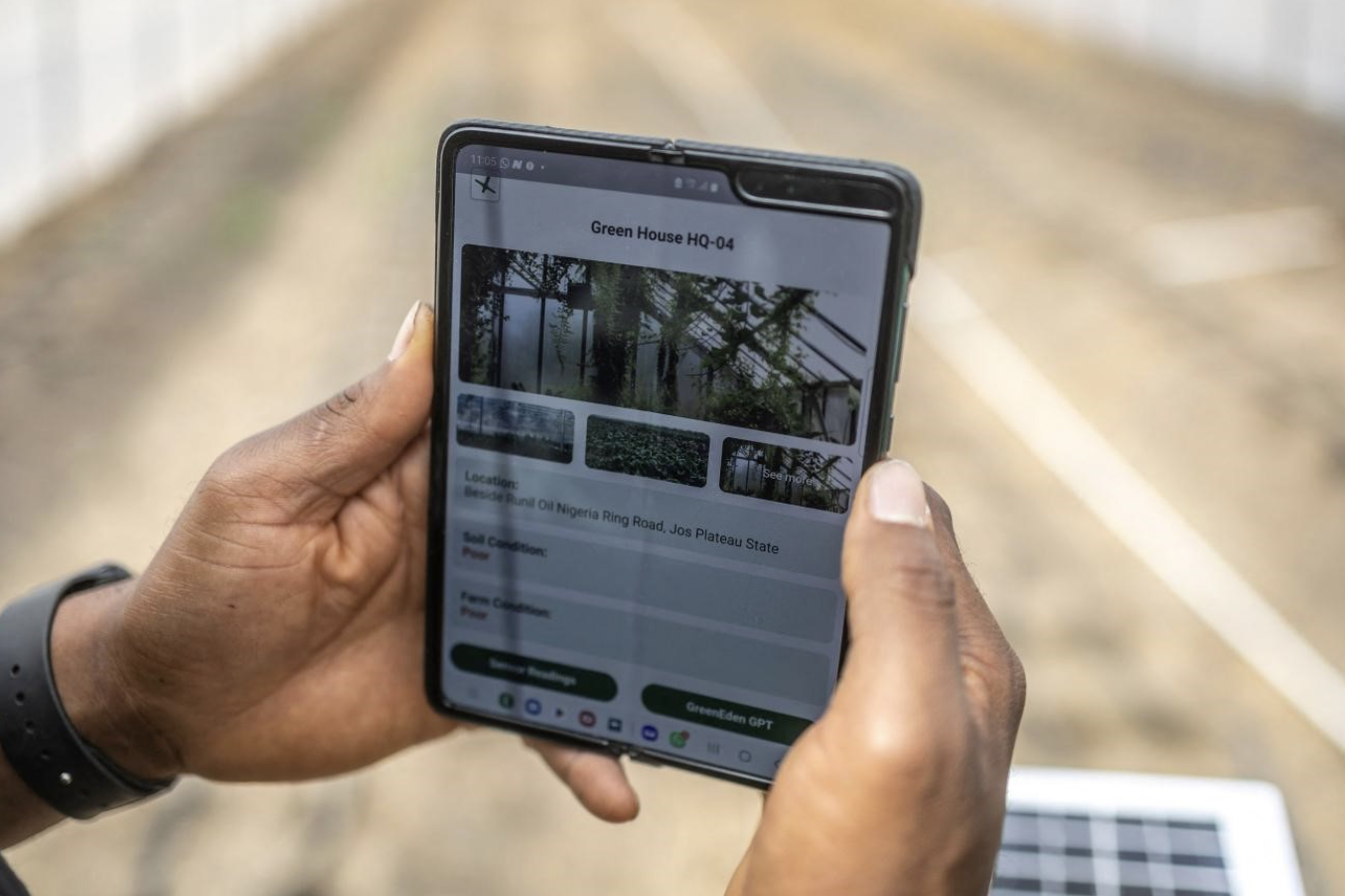 A Green Eden worker holds a phone displaying the ScareGrow app in a greenhouse using local agri-tech technology in Jos, Nigeria, February 28, 2025. /CFP