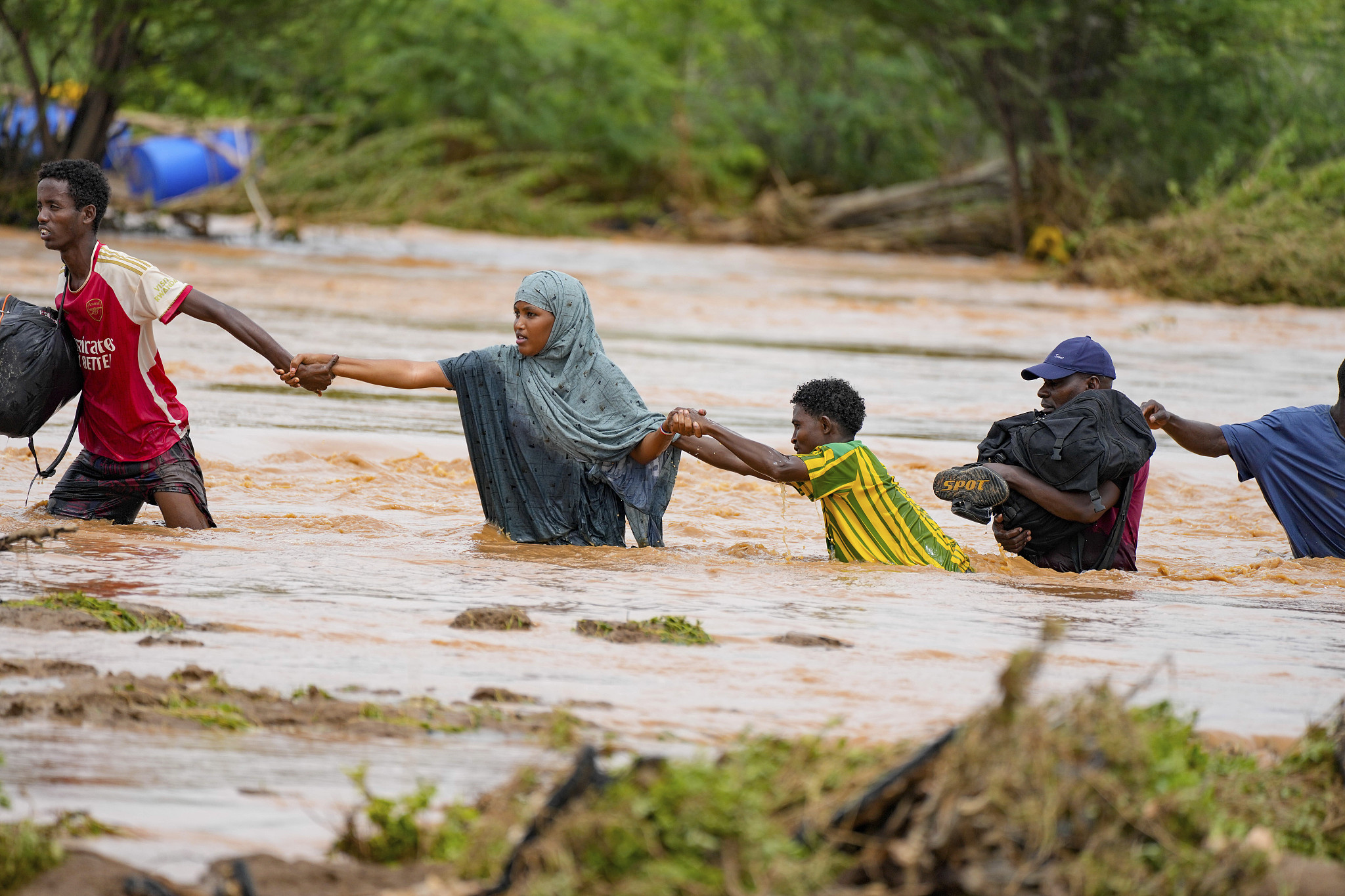 Residents cross a road damaged by El Niño rains in Tula, Tana River county in Kenya, November 25, 2023. /CFP