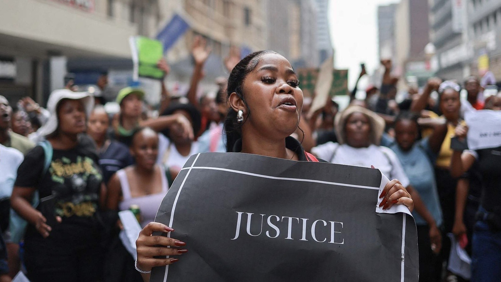 A demonstrator holds a placard while singing and chanting slogans during a protest march against gender-based violence and femicide in Pretoria Central District on April 8, 2025. /CFP