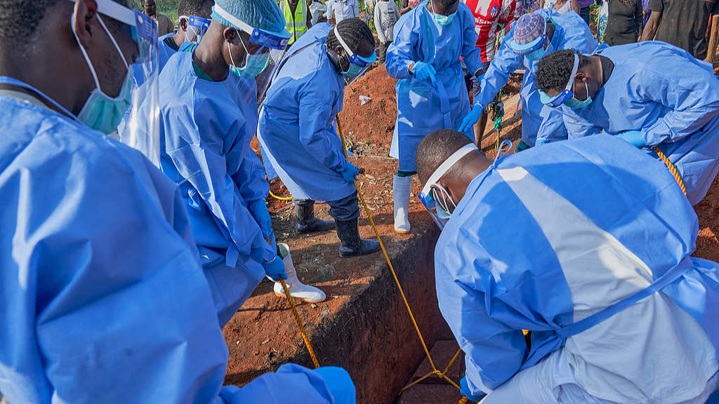 Staff lower the coffin of an Ebola victim into a grave during a burial ceremony in Bunia, Ituri Province, Democratic Republic of the Congo, July 22, 2026. /VCG