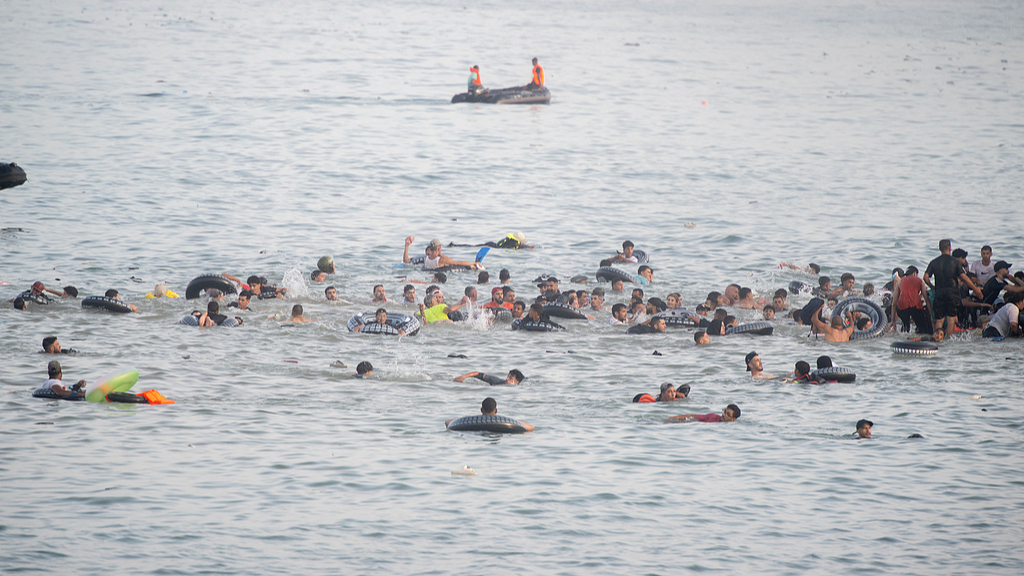 Hundreds of people of Maghreb origin cross into the city from Morocco by swimming or climbing a breakwater, in Ceuta, Spain, July 30, 2026. /CFP