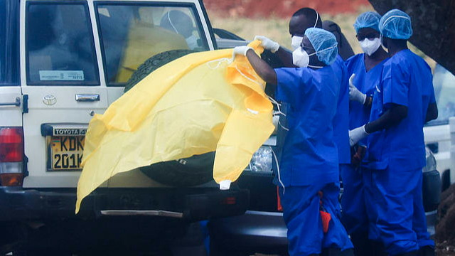 Health officials and Kenya Red Cross officials, wearing protective gear, prepare to bury Kenya's first Ebola patient at Langata Cemetery in Nairobi, Kenya, October 6, 2026. /VCG
