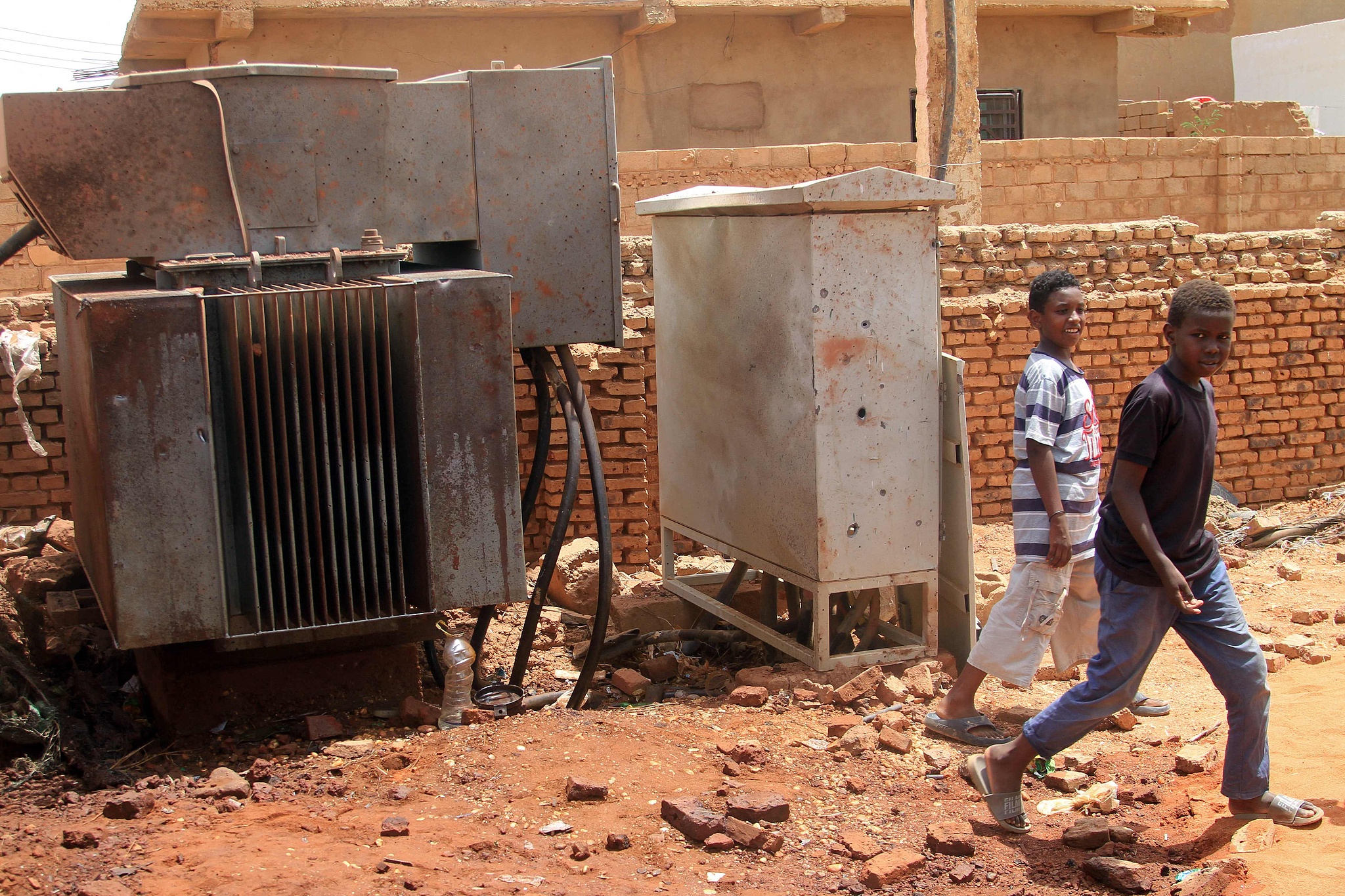 FILE: Boys walk past an electricity transformer that was hit by a drone strike in the El-Droshab area of Khartoum North, on August 12, 2026. /VCG