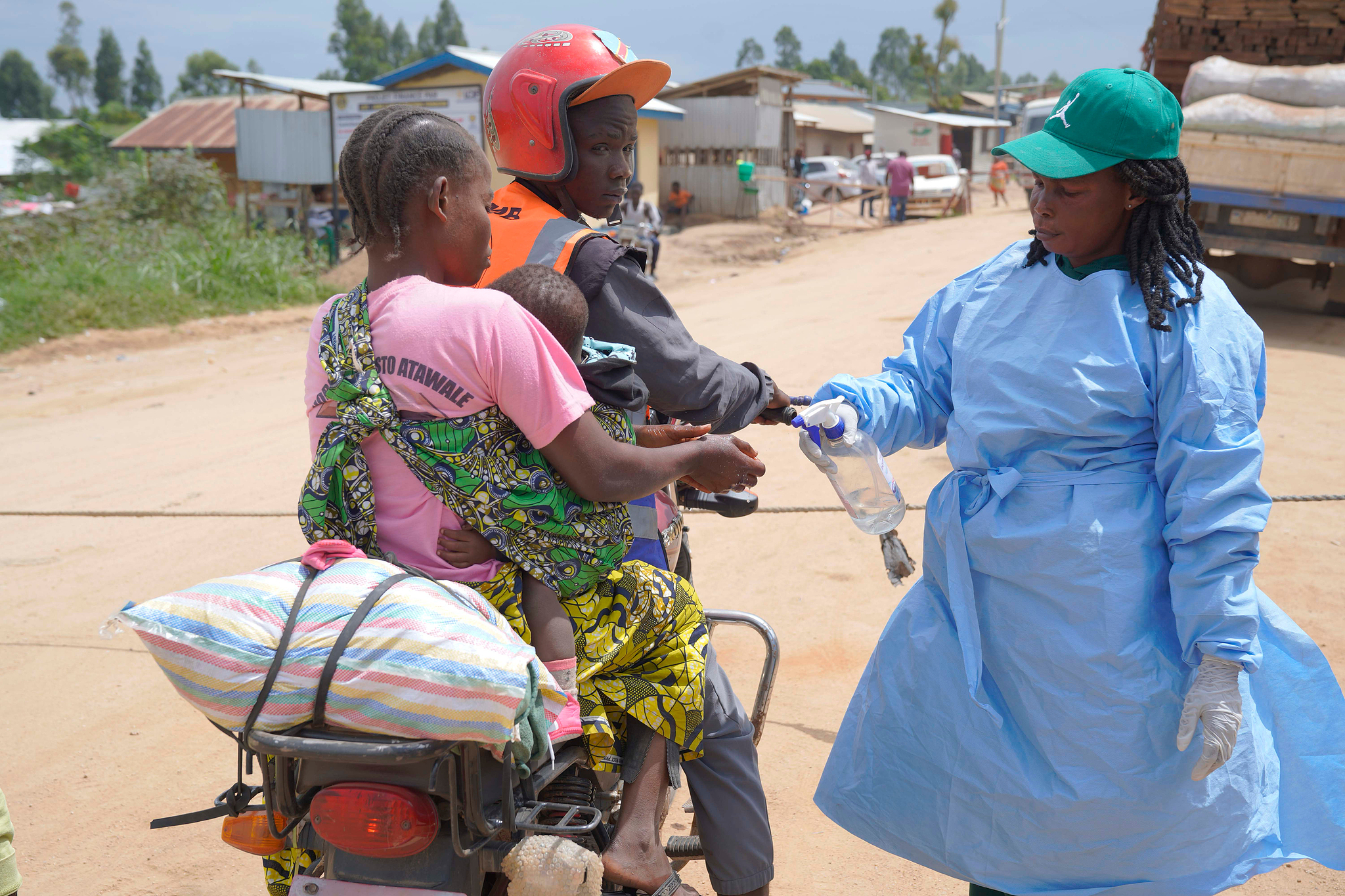 A health worker sprays disinfectant for people as they cross the Tchai checkpoint, set up to contain the spread of Ebola virus, between Ituri and North Kivu provinces, in Congo, Friday, October 23, 2026. /VCG