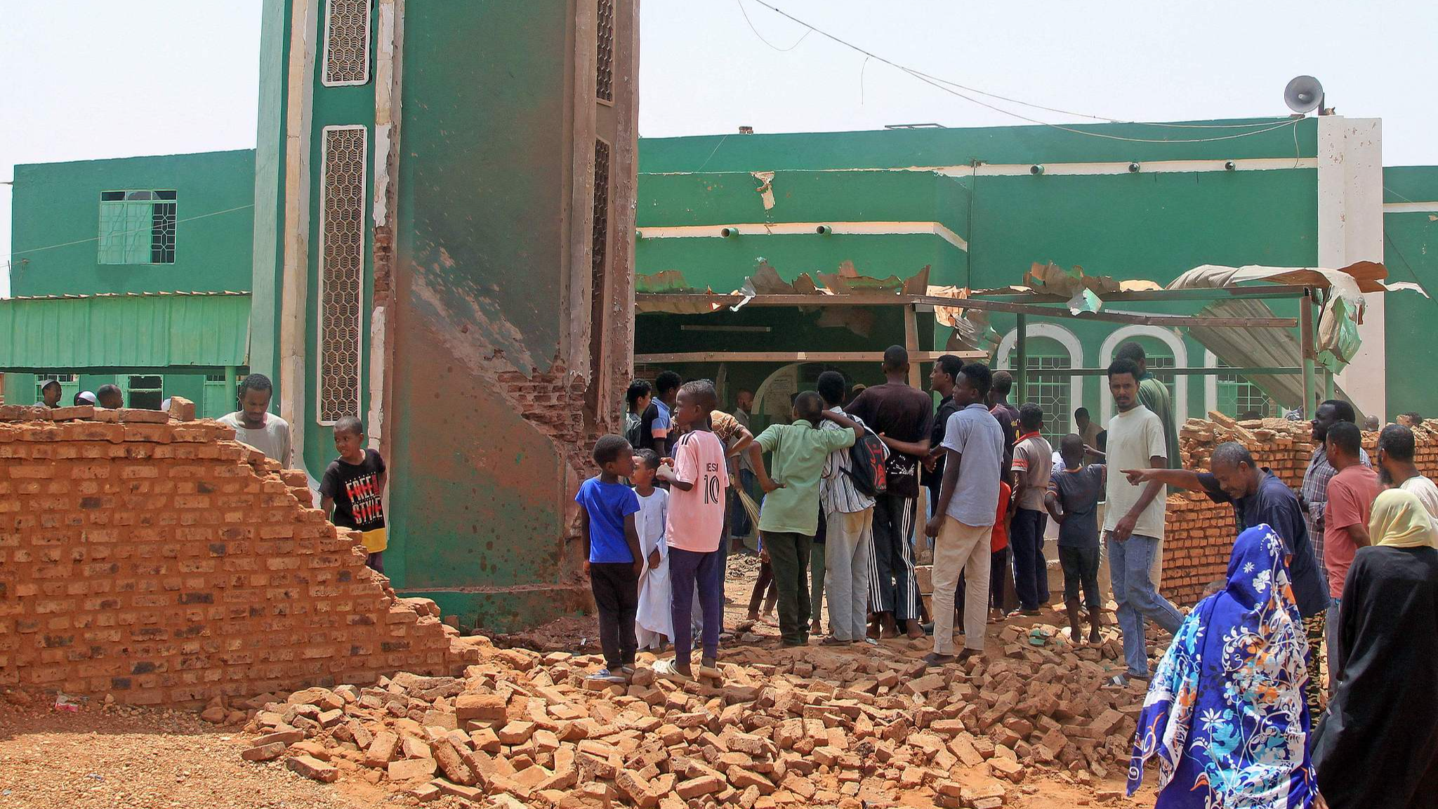 People gather to clear debris from the complex of a mosque that was hit by a drone strike in the El-Droshab area of Khartoum North, on August 12, 2026. /VCG